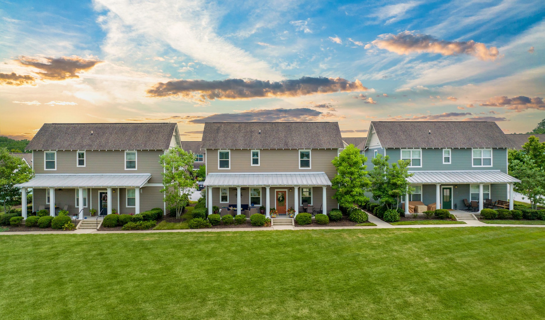 Exterior of three cottage homes Exterior of three cottage homes with large front porches and large green space in front